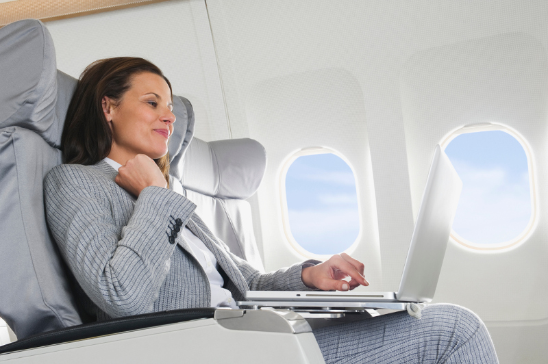 A woman using a laptop on the plane