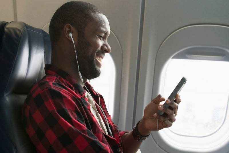A smiling man listening to something on his phone