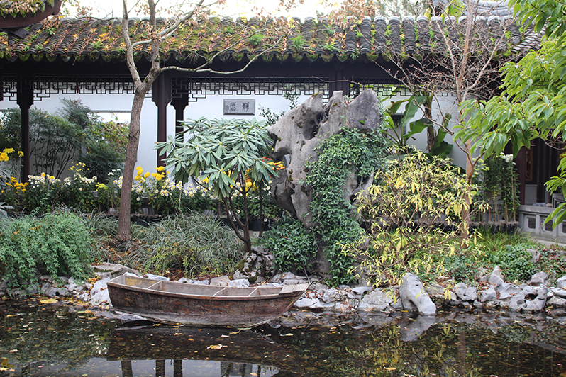Portland's Lan Su Chinese Garden lake in November with autumn leaves and a boat