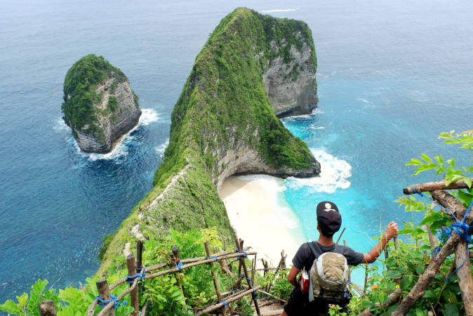 a man looking out onto a beautiful landscape of cliffs that stretch out into the ocean