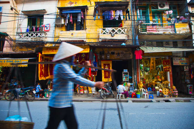 a Vietnamese man walking in a colourful vetnamese street