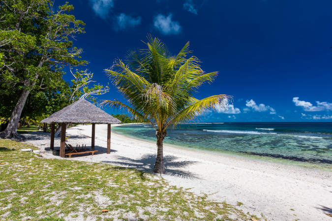a shack on a white sandy beach looking out to the ocean. It's a sunny day