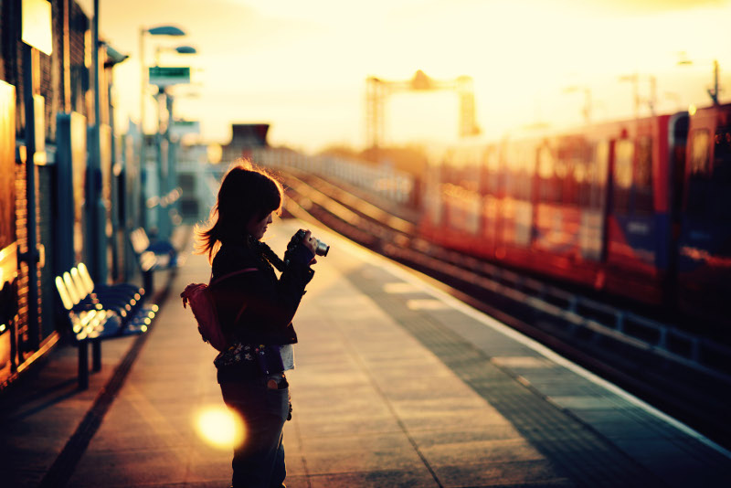girl with camera on train station