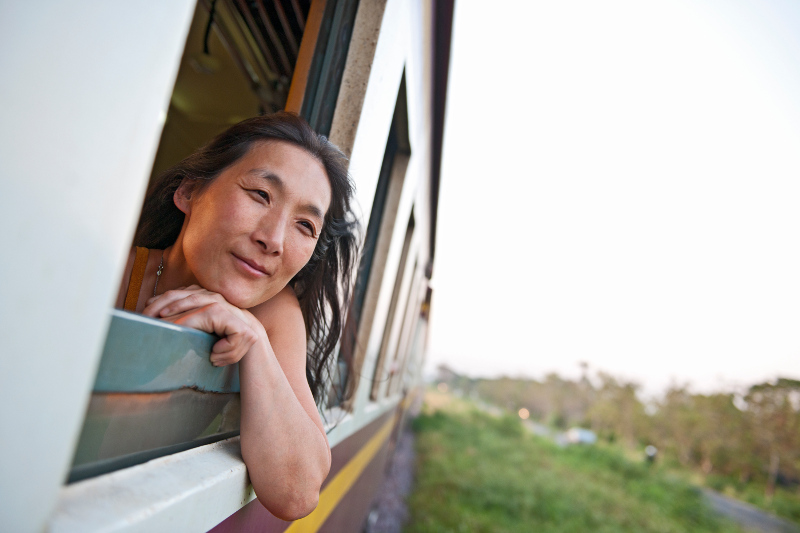 asian woman with head out of window of train