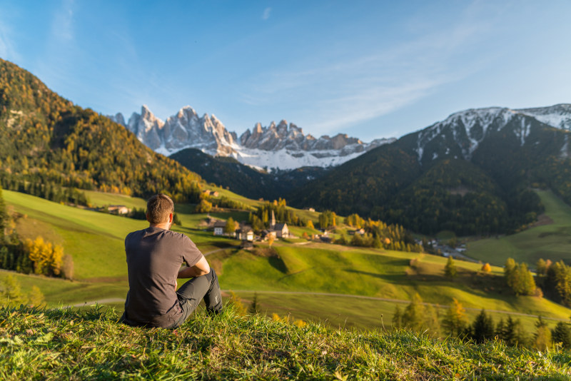 young man sitting on hill top, south tyrol