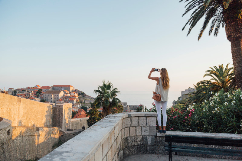 woman taking photo on phone in europe