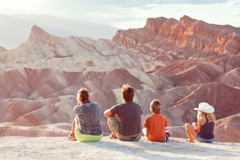 family sitting and taking in the view of a red canyon