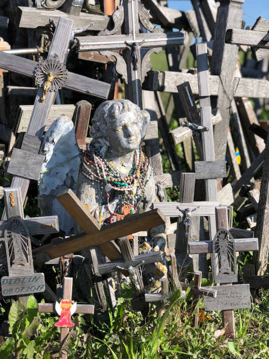 Wooden angel carving with wooden crosses around it