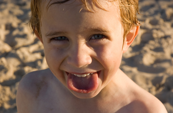 A closeup of a cheeky boy on the beach at Port Macquarie, New South Wales.
