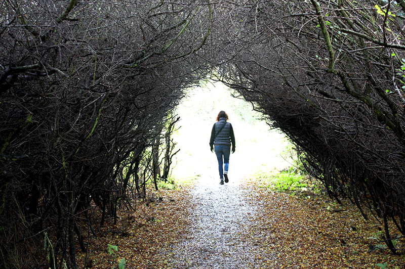 A woman walks down a coastal path in Robin Hood's Bay, North Yorkshire.