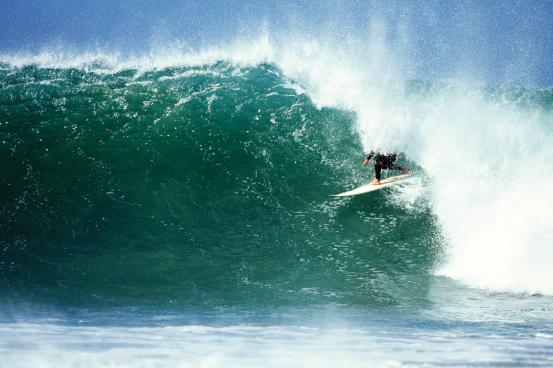 A close up of a surfer catching a wave
