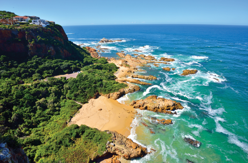 A sunny day at Knysna Heads, the ocean is meeting the sand and headland