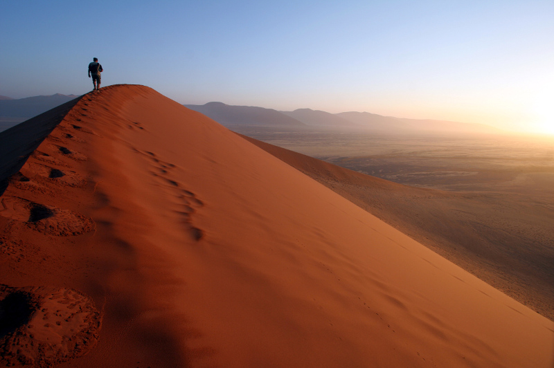 Man walking along a sand dune in Namibia
