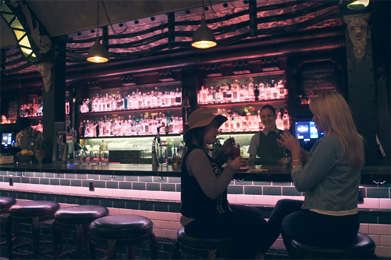 Two women sit at the Whitechapel Gin Bar in San Francisco.
