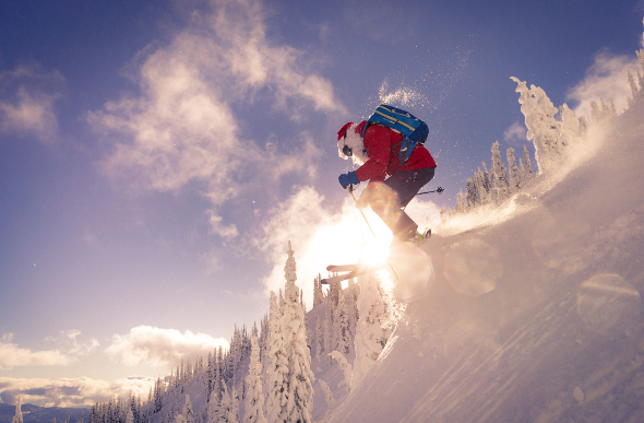 A man dressed as santa skiing down a slope