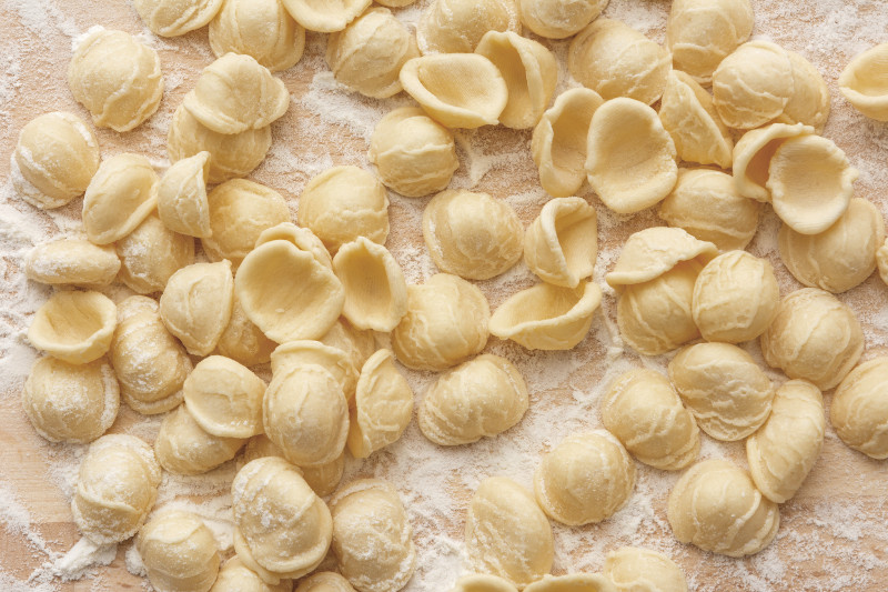 Orecchiette left out to dry in flour on table.