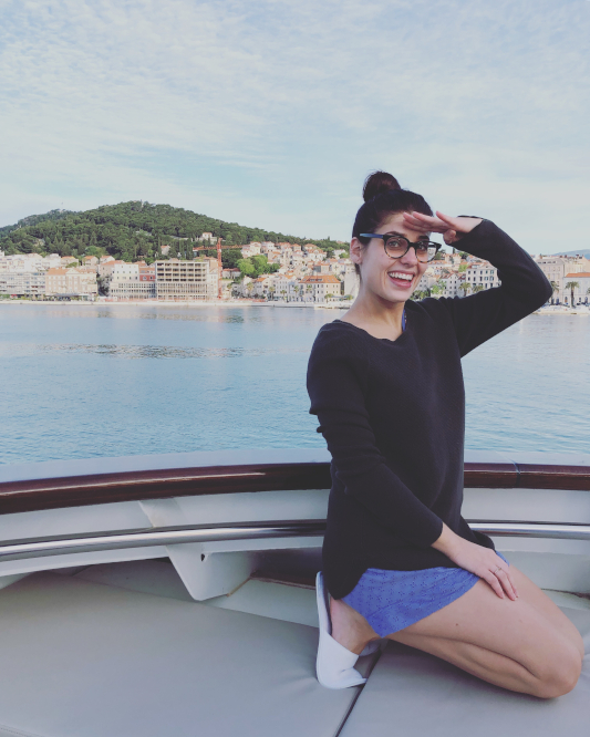 Sheridan sitting on the top of the ship in pyjamas watching the ship cruise out of Split