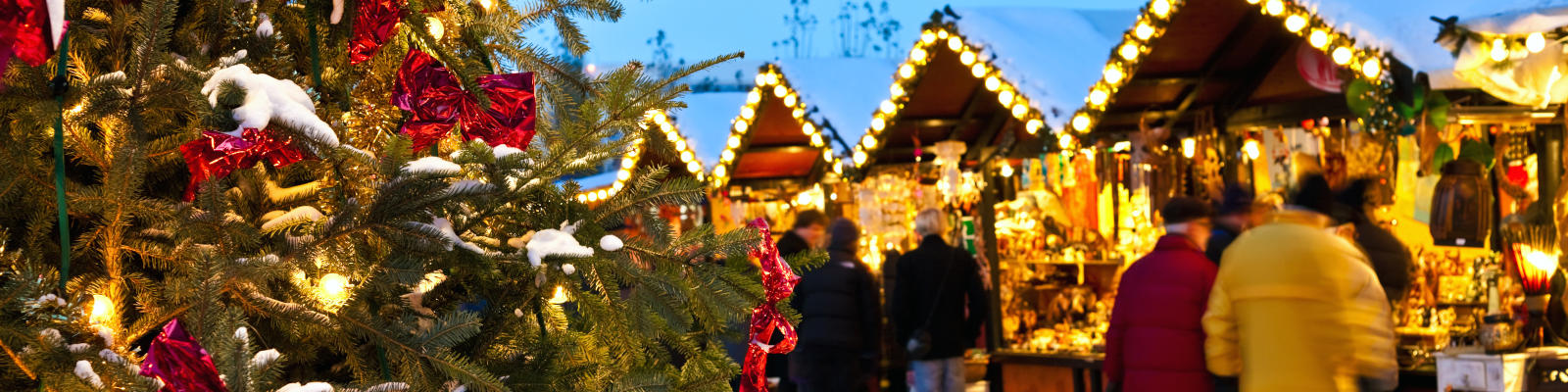 Christmas tree and people browsing the christmas market