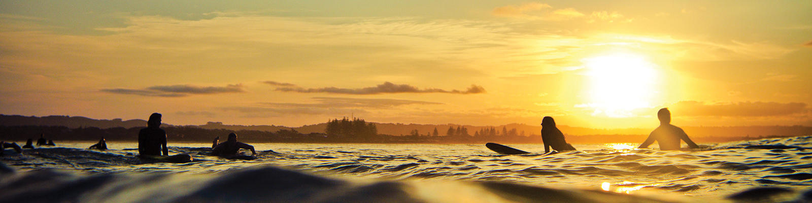 byron bay surfers at sunrise