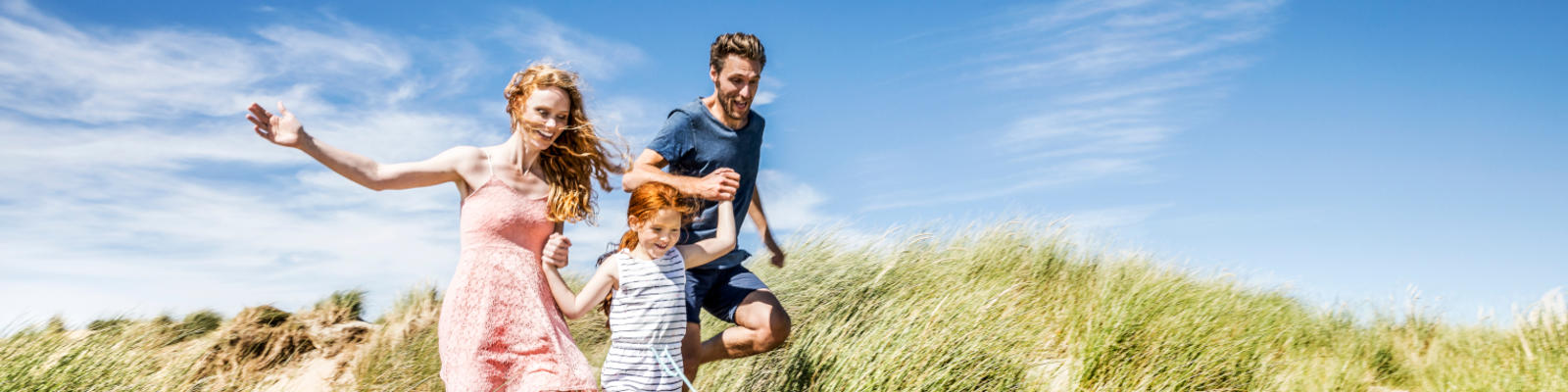 Family running along a sandune