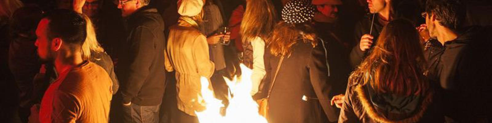People by a fire outside at the Dark mofo festival in Hobart.