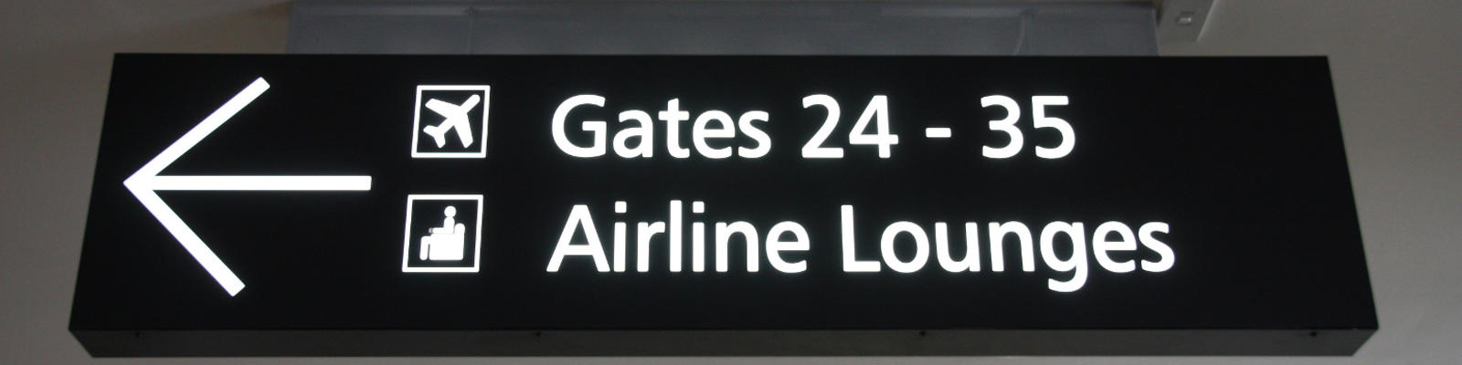 A sign in the airport pointing to gates and lounges