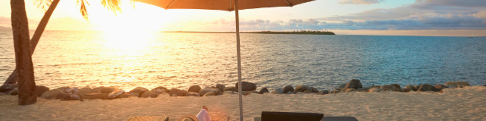 Loungers on the Fijian beach at sunset