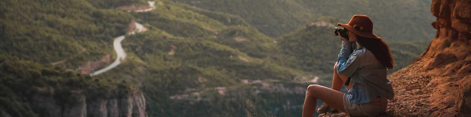 girl on mountain taking photo