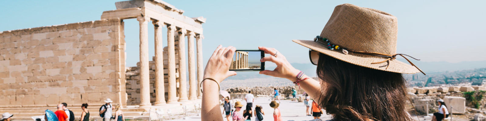 woman holding up a phone to take a photo in Athens