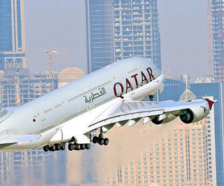 qatar a380 flying with doha skyline behind