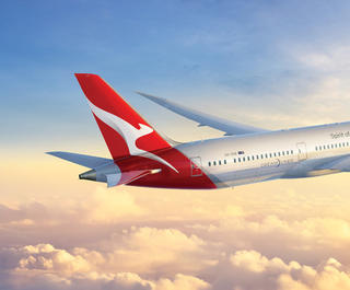 The Qantas Dreamliner flies through the clouds.
