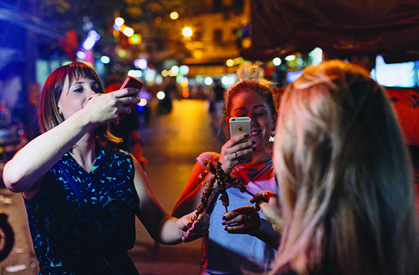 group takes photos of street food in ho chi minh city