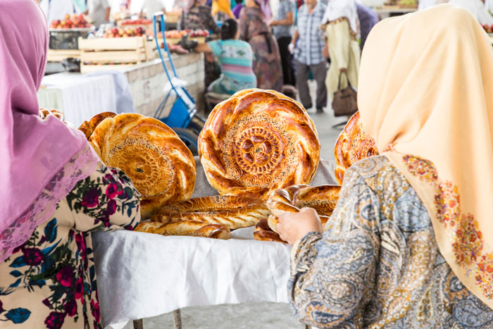 women inspect fresh baked bread in Uzbekistan