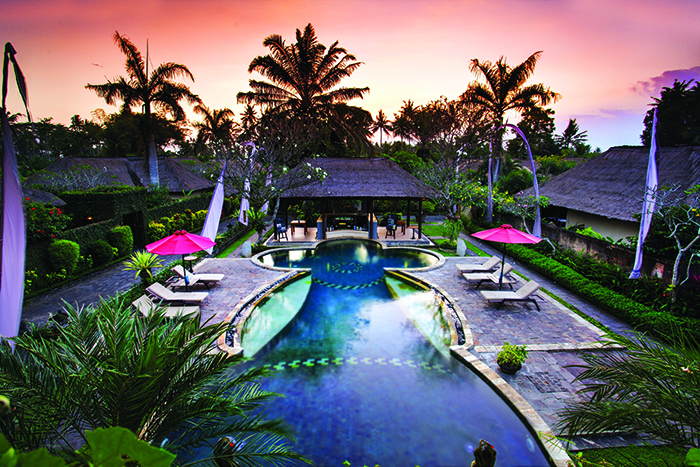 a view of the main pool, the sun setting in the background