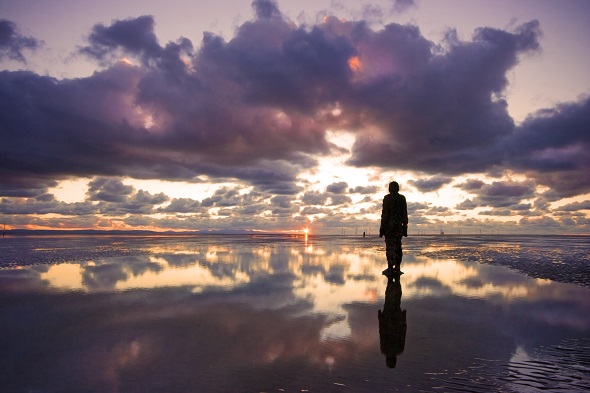 statue at sunset on crosby beach liverpool