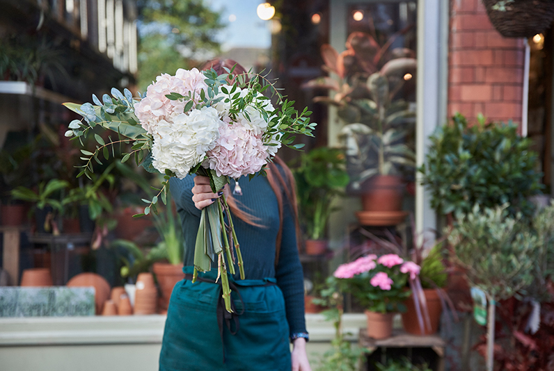 Woman holding bunch of flowers standing outside Northern Flower, Manchester