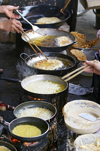 women cooking pancakes over fire in vetnam