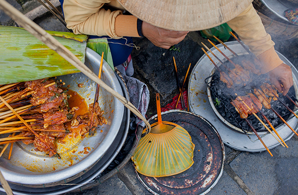 woman sells grilled meat in vietnam