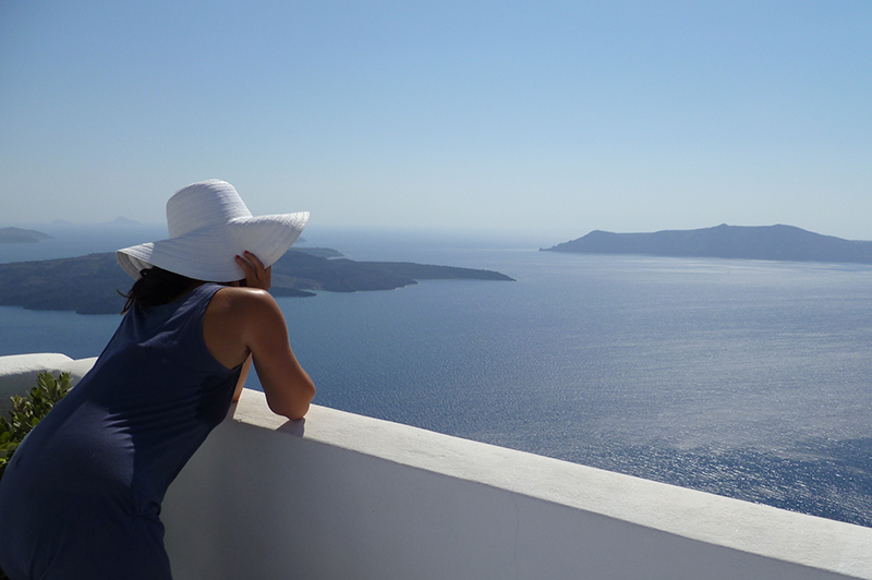 A woman looks at the sea from a Santorini villa.