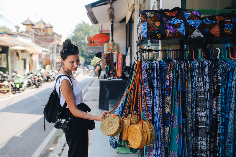 woman at market stall touching a bag